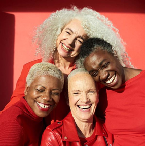 Photo of Four smiling women in red